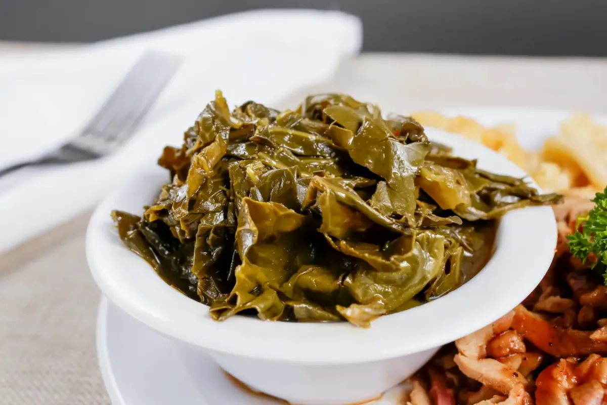 A closeup view of a small bowl of collard greens as a side dish.