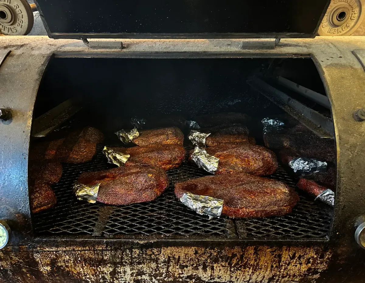 Several Nashville beef briskets, seasoned with salt and pepper, cooking low and slow.