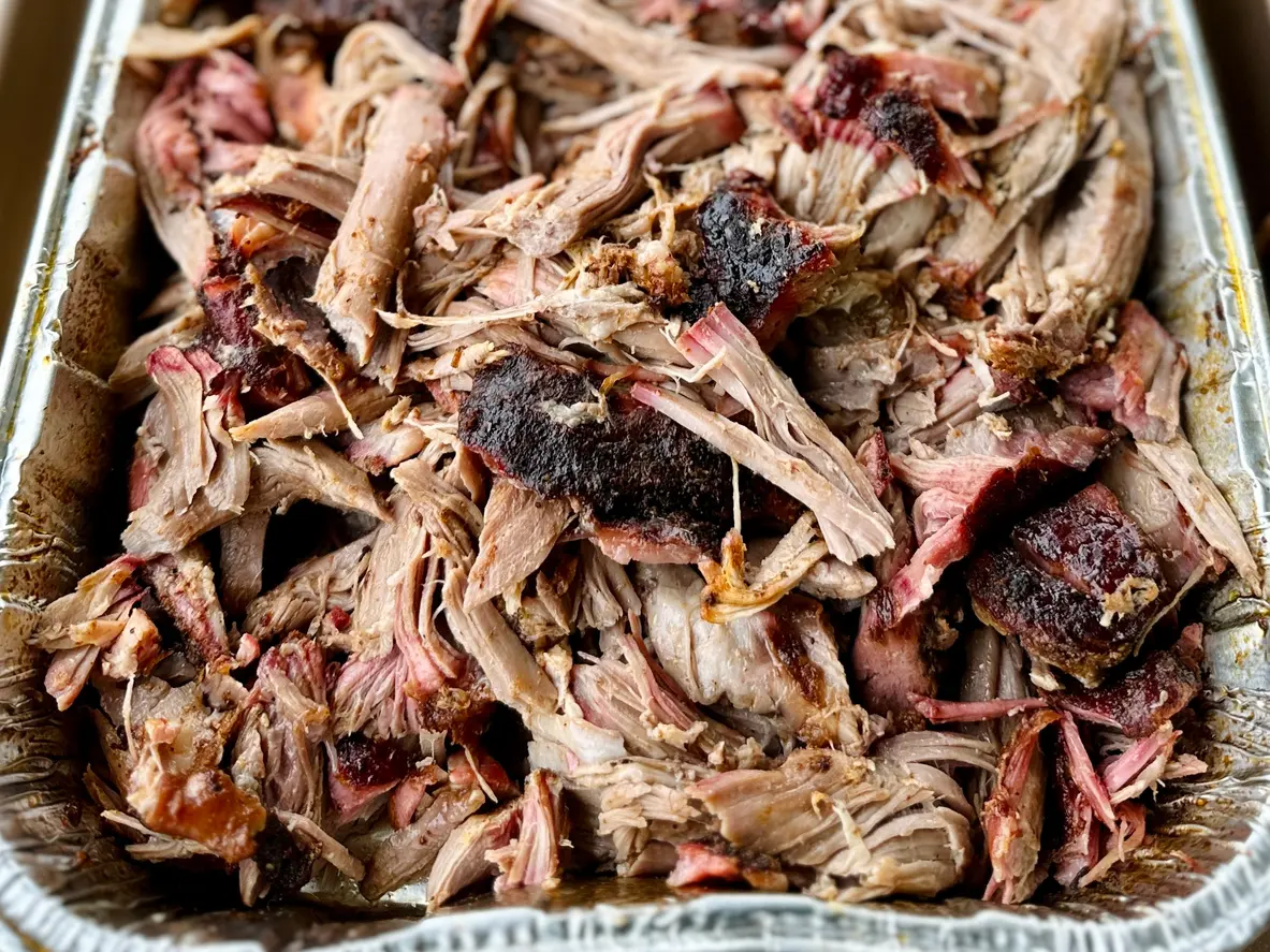 A platter filled with BBQ pulled pork that was shredded after it was cooked on a smoker following traditional Nashville barbecue cooking technique. 