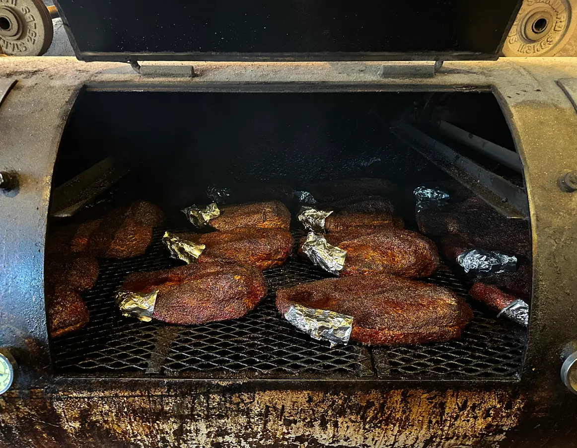Several Nashville beef briskets, seasoned with salt and pepper, cooking low and slow. 