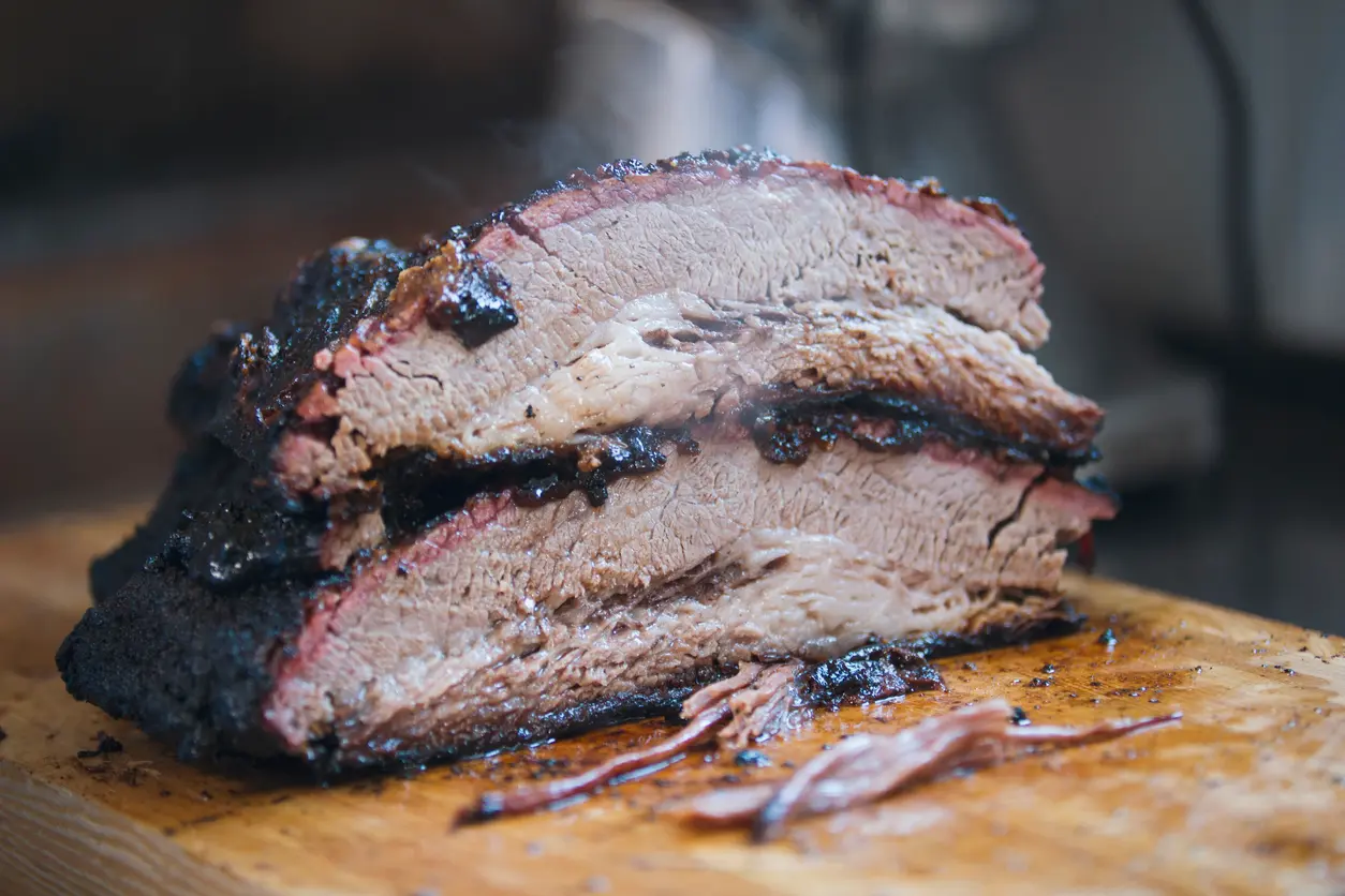 Smoked brisket meat on a wooden board. 