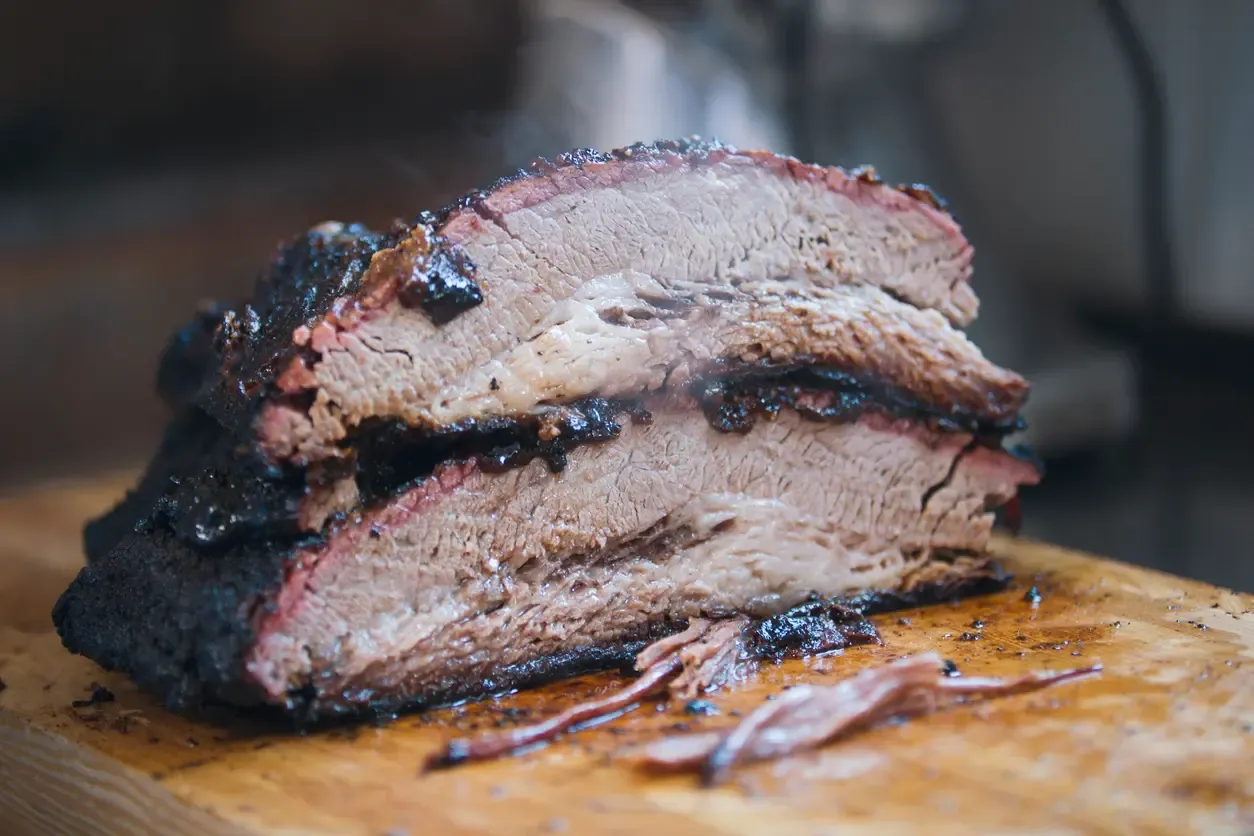 Smoked brisket meat on a wooden board. 